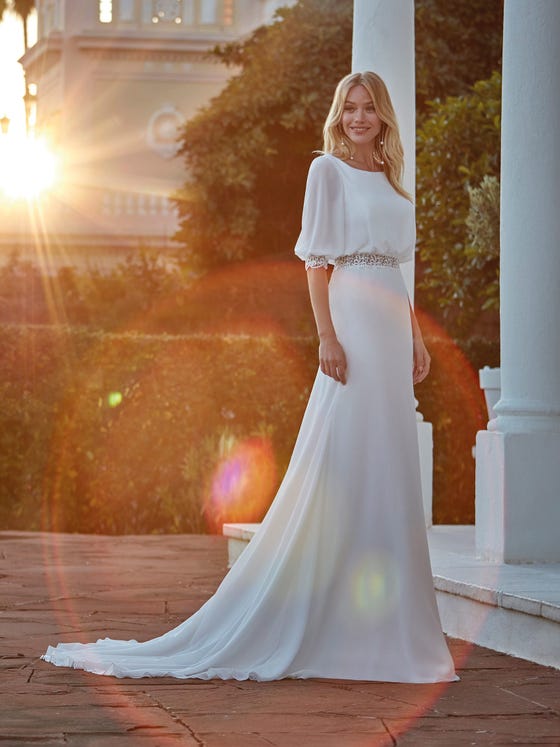 Elegant and sophisticated. Flowy design in georgette with a sensual bateau neckline decorated with strips of guipure and totally trendy puffed sleeves edged in guipure as well. 