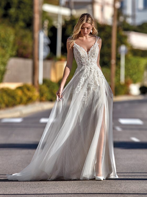 With a bohemian feel, this design with a flowy tulle skirt accentuates the femininity of the silhouette with a lace bodice and sensual V-neck decorated with beaded straps. 