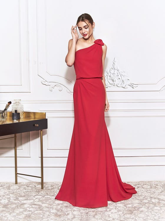 Luxurious red dress with relaxed, asymmetrical bodice and chic,  one-shoulder bow detail, finishing in a gently draped mermaid skirt. 