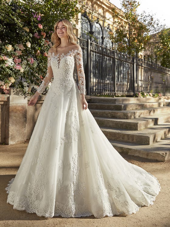 Like the denouement of a princess tale, this fabulous tulle and lace wedding dress enhances the volume of the skirt and contrasts it with the tulle illusion neckline and sleeves. 