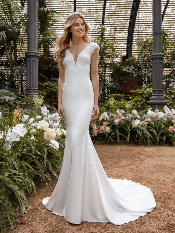 An impeccable cut in soft, liquid crepe highlights your curves in this mermaid gown that features a plunge back and clusters of feathery applique on the shoulders.  
