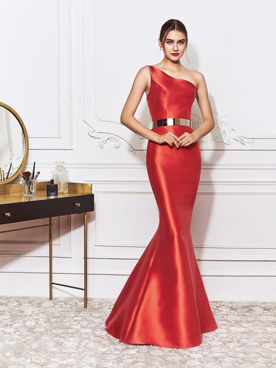 Stunning mermaid gown crafted in glossy red Mikado, featuring  a chic, asymmetrical neckline, slender, fitted waist, and a statement train with a bold trumpet cut. 