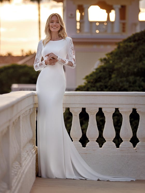 Elegant mermaid crêpe dress with long sleeves, bateau neckline and closed back with tulle appliques and transparencies. 