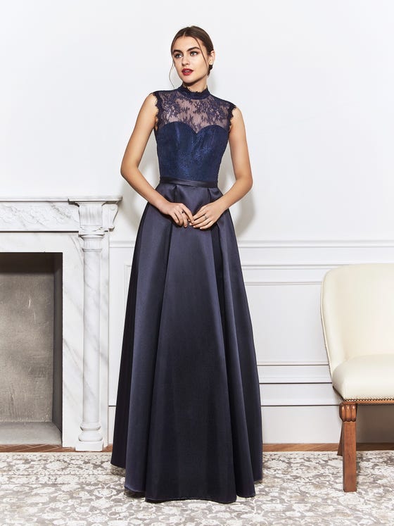 Navy blue gown with sweetheart bodice coated in Chantilly lace that crafts a slight turtleneck and keyhold back, finishing in a sleek waistband and a structural, low-volume princess skirt. 
