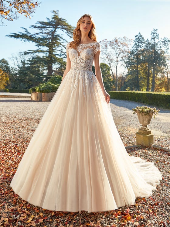 A cloud of embroidered tulle creates a fantasy princess-style gown with a softly layered skirt and off-the-shoulder bodice in fine guipure lace.   