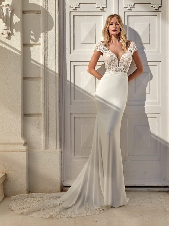 Beautiful mermaid dress that combines a crêpe skirt featuring a very feminine silhouette with a bodice with lace and beading appliques, matching the decoration on the V-back and train. 