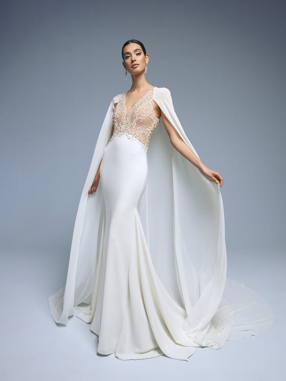 Spectacular dress that looks like a two-piece. It combines the elegance of crepe with a fabulous figure-fitting mermaid skirt with a provocative, sensual jeweled bodice in tulle and beading and a plunging V-neck. You can wear it with the chiffon cape to make it even more glamorous. 