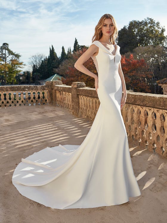 A chic and sophisticated look for the modern bride, tailored in pure crepe with a gossamer-fine illusion back scattered with pearls, deep V neck and flowing royal train.  