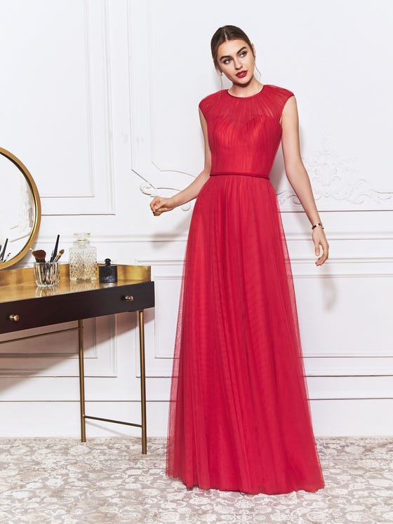 Rays of finely folded drapery start at the high neckline of this sheath gown, extending into the cap sleeves and down the sweetheart bodice before finishing at a minimalist waistband that wraps around to a refined, keyhole back. 
