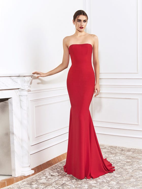 Stunning gown in cherry red, stretch crepe, designed with a strapless neckline and a tightly fitted skirt that finishes in a cascading, rippled train at the back. 
