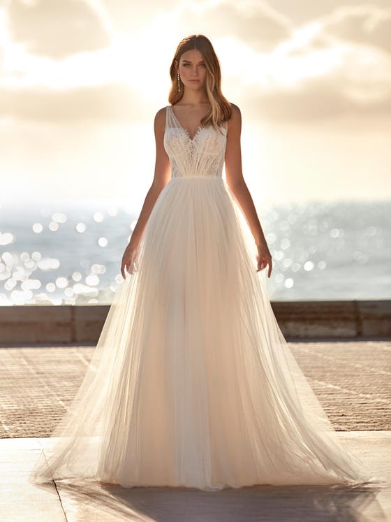 Romantic tulle A-line dress. A sensational design with Chantilly and lace appliques on the bodice and sensational draped tulle at the neck and back, creating a very sensual V-look. You can complete the look with long bishop sleeves to give it a more bohemian feel. 
