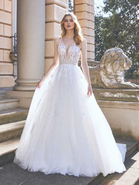 Transparencies, flowers and a magical illusion back. A princess tulle design that manages to combine the delicacy of the fabric and the freshness of flowers to create a very feminine look enhanced by the pronounced illusion neckline edge in guipure. 