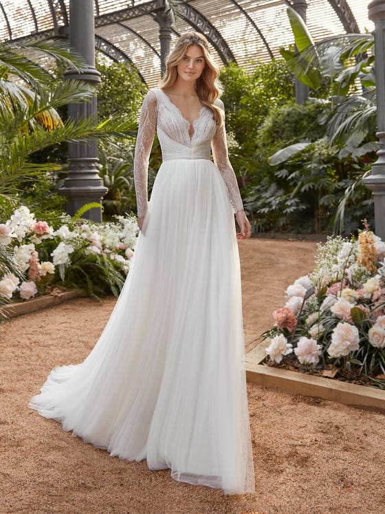 Long-sleeved, but still light and feathery, this soft tulle dress features sparkly lace and puckering over the bodice and V-shaped back. The layered skirt moves like a dream.  