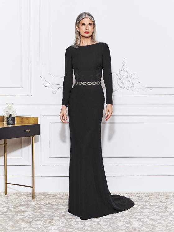 Minimalist mermaid gown in black crepe, designed with long sleeves, a high neckline, and a fitted silhouette that finishes in an understated scoop back. 
