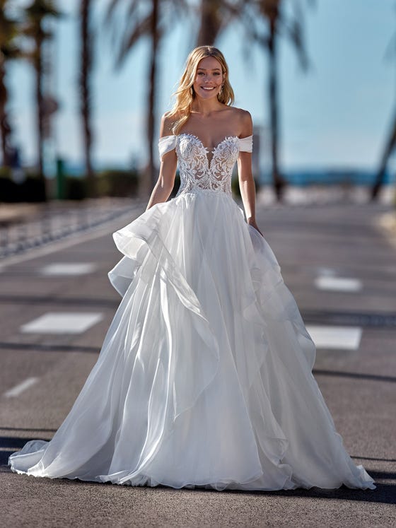 Wonderful princess-style dress with an organza ruffled skirt along with a semi-transparent tulle bodice with lace and sequin appliques that create a lovely sweetheart neckline with a more plunging V-neck, along with draped organza sleeves. 