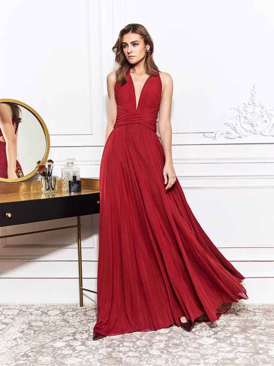 Pleated sheath gown in rich scarlet, designed with a  cross-over waistband and a plunged, halter neckline that intersects in an angular, keyhole back. 