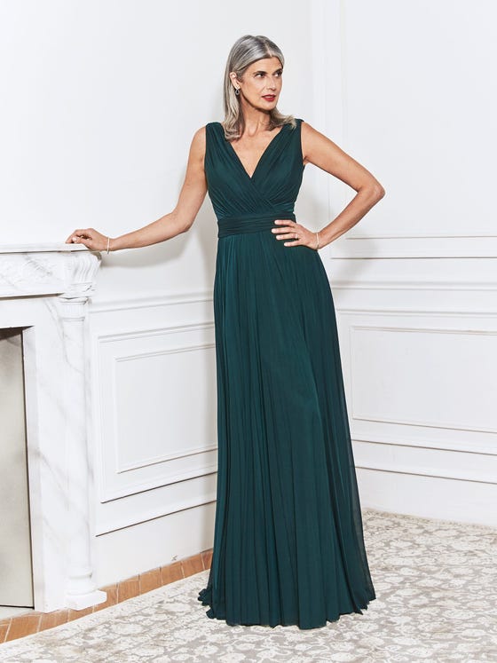 Pleated sheath gown in rich, pine green, featuring lightly pinched V-neck bodice and incredibly graceful lines on a draped back that finishes in a graceful skirt of stretch tulle. 