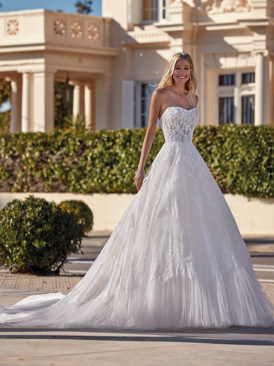 Beautiful princess-cut dress with a sweetheart neckline and sensational play of lace that descends along the entire design until creating a low tulle ruffle on the skirt. 