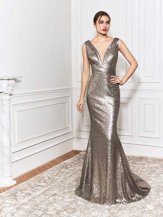 Metallic, golden sequins coat the sloped, plunge neckline, draped waist, and fitted skirt of this shimmering mermaid gown, which finishes in a sleek V-back and rippled train. 