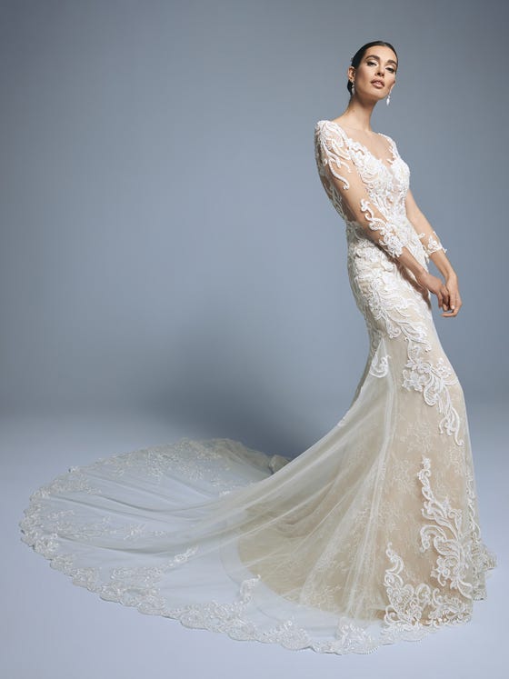Romantic, sensual and slightly bohemian. A design that plays with the femininity of the silhouette with embroidered tulle and Chantilly lace. A dress with a long train, long sleeves and a semitransparent bodice with a V-neck and illusion back. 