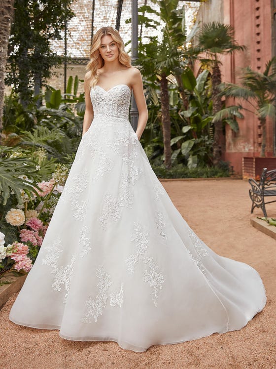 The princess wedding dress couldn’t be more perfect with its boned, lace bodice and full, layered skirt featuring clusters of floral embroidery. With a scooped back and a traditional chapel train.  