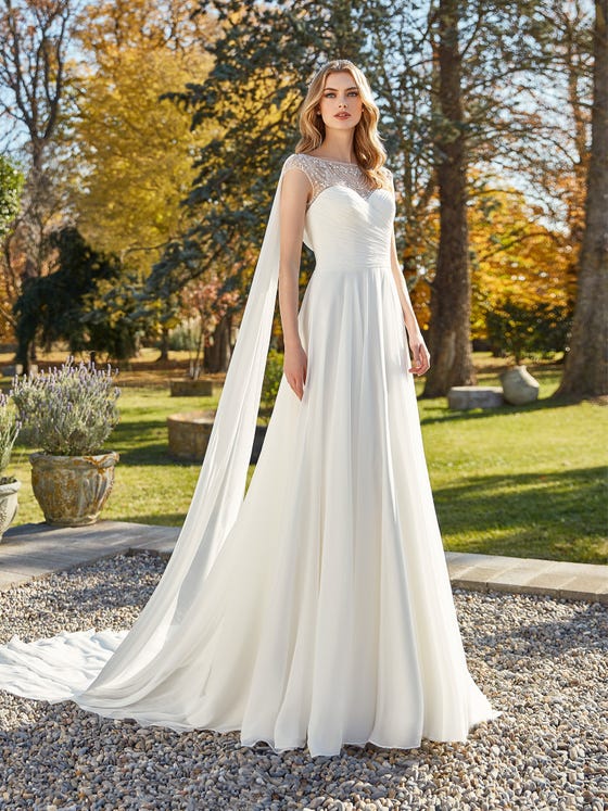 A magical evasée-style gown crafted in layers of fine chiffon and a glittering mesh neckline. With an artfully draped sweetheart bodice and detachable tails for maximum fluidity.  