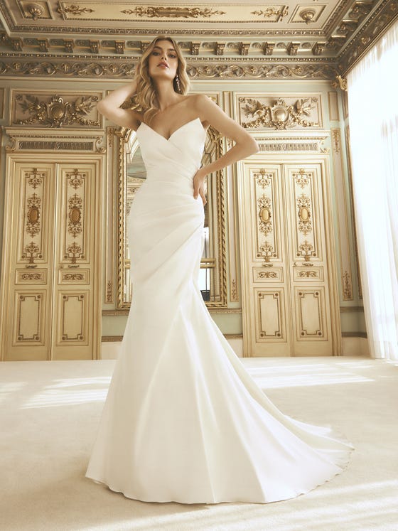 Very glamorous. A spectacular wedding dress that spotlights extra-large draping to create movement and slim the silhouette. A design with an original neckline with a knit border which wraps around the hips, turning the silhouette into the perfect sculpture. 