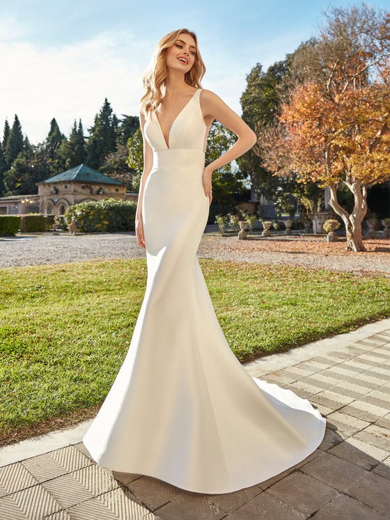 Glossy Mikado enhanced with a touch of stretch adds form and ease of movement to this minimalist mermaid gown. With a delicately beaded illusion back and plunge neckline ending in a waist-defining bandeau.  