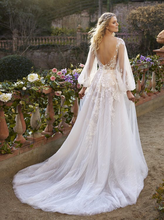 A stunning dress covered in beading and floral details wrapping around the silhouette. This design plays with the transparencies of the bodice, the tattoo effect of the back and the skirt to enhance the femininity of the look. Plus, long voluminous sleeves give it a much more magical, naïf look. 