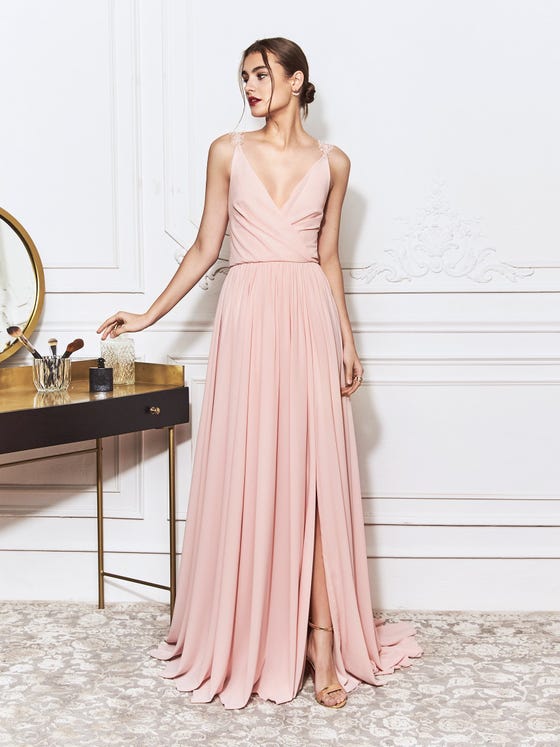 Darling gown in powder pink Georgette with crossover bodice of light, rippled drapery, lace placements at the straps, and a billowing sheath skirt with slit. 