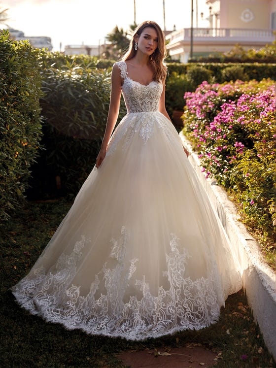 Spectacular princess-style dress in tulle and Chantilly with a scalloped train decorated with lace and beading appliques to go with a bodice with a round neck front and back, short sleeves and a cascading look at the waist. 