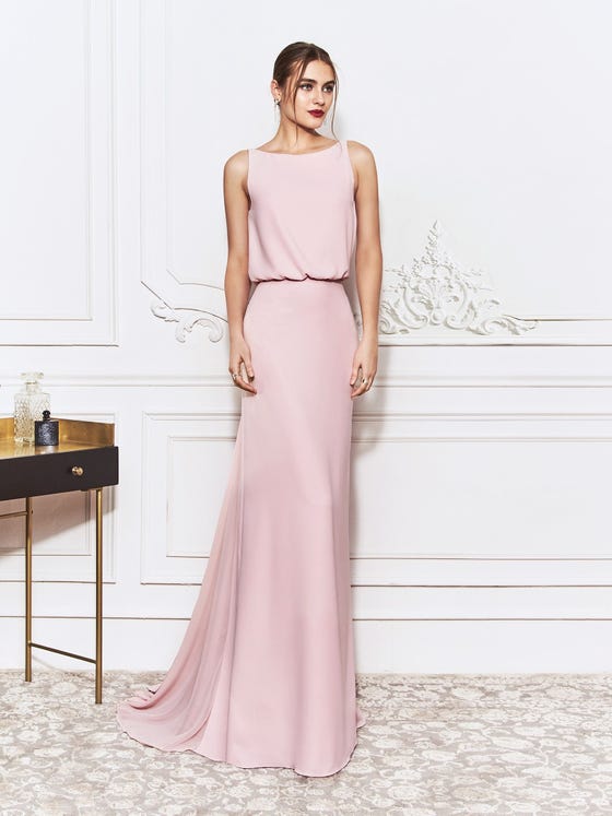 Handsome sheath gown in soft pink, designed with bateau neckline, billowing bodice, and gorgeous, open back of loose drapery, finishing at the cinched waist of a relaxed skirt with rippled, tulle panelling. 
