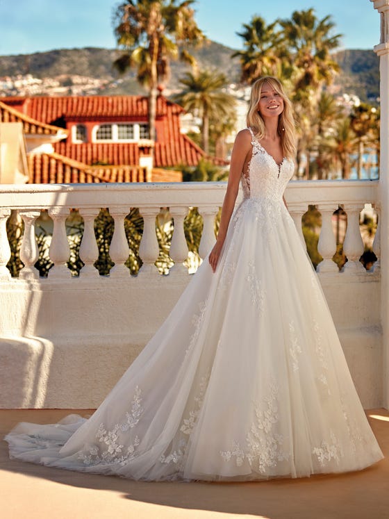 Fabulous A-line dress with a V-neck and cut-out look with transparencies on the sides. A design in tulle with lace and beading appliques that accentuate the femininity of the lines. 