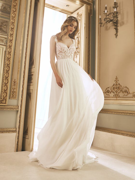 The essence of lightness and romanticism merge in this incredible chiffon dress with a semitransparent bodice decorated with lace appliques and sparkling beading around the neckline. 