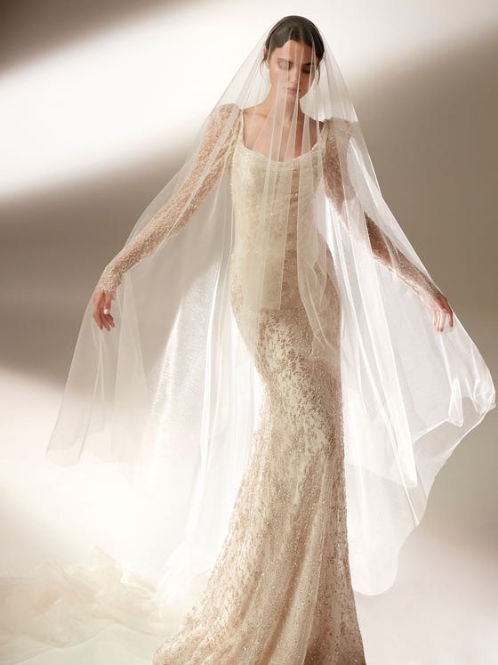 Der fließend fallende Schleier aus schwerelosem Tüll umgibt die Braut mit einer romantischen Aura und harmoniert mit allen Kleidern. 